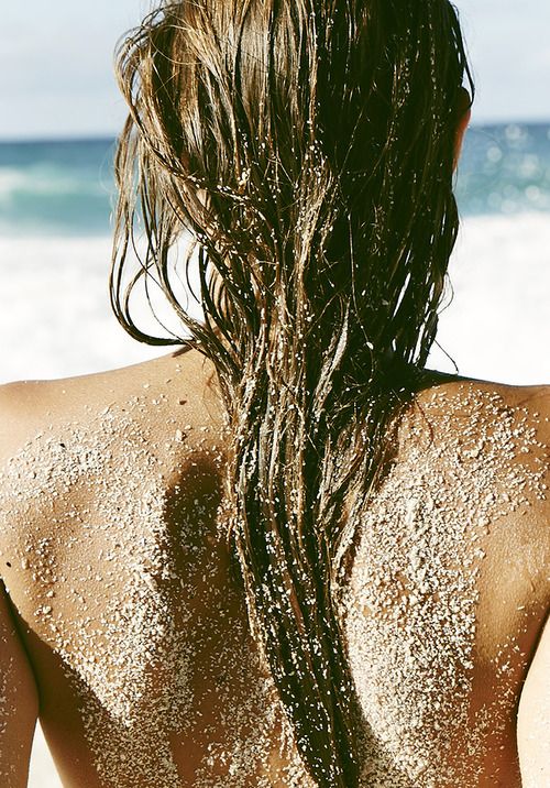 vrouw op het strand met zand in het haar.